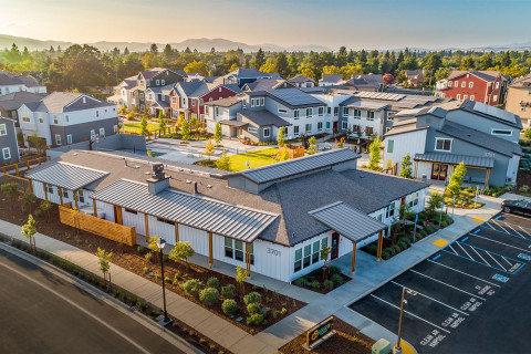 Aerial photo taken at sunset of Sunflower Hill at Irby Ranch in Pleasanton, CA. This photo shows the entirety of the community with long sweeping shadows as the sun sets over the mountain range to the west. The community courtyard is illuminated with an a